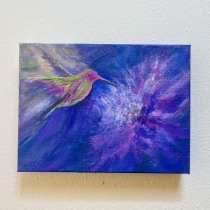 Acrylic painting on canvas of a hummingbird hovering near a purple flower hanging on a gallery wall